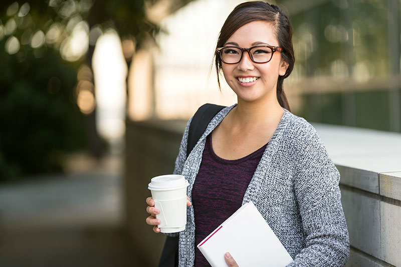 young asian female glasses smiling outdoors