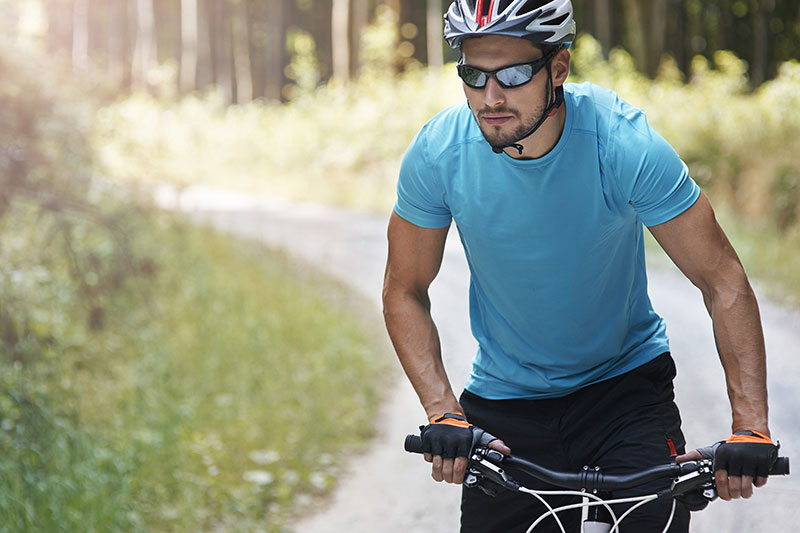 white male riding bicycle wearing sunglasses