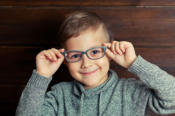 Youth boy pediatric holding eyeglasses